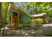 Charming blue and yellow home featuring a wooden porch and gravel driveway at 9709 Greenfield Rd, Chapel Hill, NC 27516