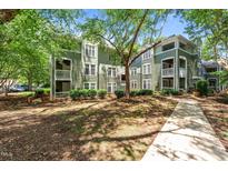 Green, multi-story condo building with mature trees in a well-maintained complex at 1010 Nicholwood Dr # 301, Raleigh, NC 27605
