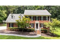 Charming red brick two-story home featuring classic black shutters and landscaped front yard at 10721 Marabou Ct, Raleigh, NC 27614
