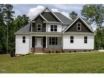 Charming two-story home with white siding, dark trim, and inviting front porch at 190 Whistlers Cv, Louisburg, NC 27549