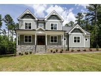 Charming home featuring stone accents, a welcoming front porch, and a beautifully landscaped yard at 200 Whistlers Cv, Louisburg, NC 27549