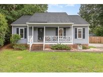 Charming single-story home with gray siding, black shutters, and a welcoming front porch at 204 Valley Ct, Selma, NC 27576