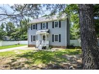 Charming two-story home with a well-manicured lawn, classic shutters, and inviting front porch at 205 Cedar Dr, Zebulon, NC 27597