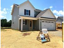New two-story home featuring a two-car garage and landscaped yard under a sunny sky at 21 Windflower Ct # Homesite 11, Clayton, NC 27520