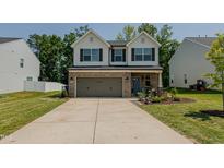 Charming two-story home with a well-maintained lawn and a two-car garage at 2586 Lacey Holt Rd, Graham, NC 27253