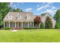 Charming home featuring a welcoming front porch with classic columns and a beautifully landscaped front yard at 2945 Chimney Hill Trl, Rocky Mount, NC 27804