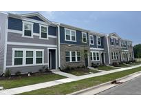 Charming townhouse exterior showcasing a mix of siding and brick, complemented by landscaped greenery at 3010 Fulong Dr, Durham, NC 27704