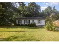 Charming single-story home features a well-maintained lawn and cozy curb appeal surrounded by mature trees at 308 Plaza Dr, Garner, NC 27529