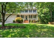 Charming two-story home featuring a large front porch and lush landscaping in a wooded community at 316 Academia Ct, Durham, NC 27713