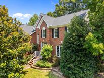 Stunning brick home featuring a well-manicured lawn and classic architectural details at 3306 Meadowrun Dr, Durham, NC 27707