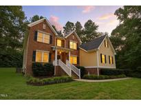 Charming two-story brick home with lush landscaping and a welcoming front porch at 3650 Pleasants Ridge Dr, Wake Forest, NC 27587