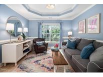 Comfortable living room with blue accent wall, natural light, and stylish furnishings at 413 Braxman Ln, Holly Springs, NC 27540