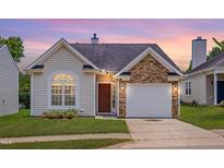 Charming home featuring stone accents, a well-maintained lawn, and an attached single car garage at 5000 Mocha Ln, Raleigh, NC 27616