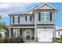 Charming two-story home featuring light gray siding and a welcoming front porch with chairs at 553 Sturgeon St, Smithfield, NC 27577
