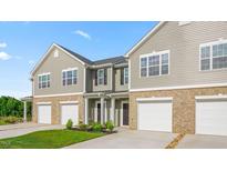 Charming townhome exterior showing garage and neutral siding and brick at 5560 Henley Ridge Dr # 187, Graham, NC 27253