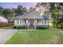 Charming home featuring a covered front porch, manicured lawn, and inviting curb appeal at 609 N Country Club Dr, Oxford, NC 27565