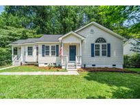 Charming home with a well-manicured lawn, blue shutters and an inviting front porch at 725 E Maple Ln, Fuquay Varina, NC 27526