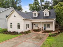 Charming home boasts a well-manicured lawn, brick-lined drive, and inviting front porch at 807 Edmund St, Raleigh, NC 27604