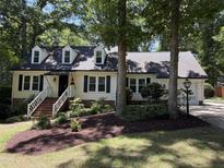 Charming home with dormer windows, black shutters, landscaped yard, and brick walkway at 8629 Windjammer Dr, Raleigh, NC 27615