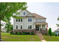 Charming two-story home with stone accents, manicured lawn, and inviting front porch at 909 Green Oaks Pkwy, Holly Springs, NC 27540