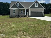 Charming two-story home featuring a covered porch, two-car garage, and neutral exterior at 106 Viola Ln, Franklinton, NC 27525