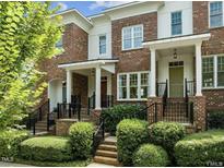 Attractive brick townhome featuring a covered entryway, manicured landscaping, and a welcoming facade at 111 Finsbury St, Durham, NC 27703