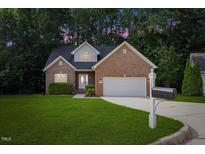 Charming brick home with a well-manicured lawn and two-car garage, perfect curb appeal at 1209 Waterford Green Dr Dr, Apex, NC 27502