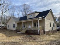 Inviting ranch-style home features a covered front porch with wooden columns and a brick foundation at 206 E Silver Belle Dr, Zebulon, NC 27597