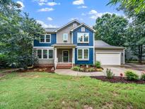 Charming two-story home with a lush green lawn and mature landscaping at 218 Inwood Forest Dr, Raleigh, NC 27603