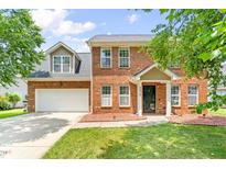 Charming two-story brick home with an attached garage and well-manicured lawn on a sunny day at 2419 Pepperstone Dr, Graham, NC 27253