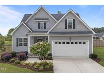 Charming gray two-story home with a two-car garage, landscaped yard, and inviting front entrance at 31 Sweet Birch Ave, Zebulon, NC 27597