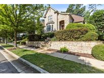 Elegant home featuring a light brick facade, lush landscaping, and a retaining wall at 3311 Canoe Brook Pkwy, Raleigh, NC 27614