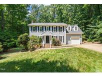 Traditional two-story home boasts a manicured lawn and classic architectural details at 3821 Whispering Branch Rd, Raleigh, NC 27613