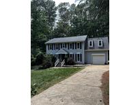 Charming two-story home with a gray exterior, black shutters, and a well-manicured front lawn at 3821 Whispering Branch Rd, Raleigh, NC 27613