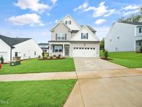 Charming two-story home with a well-manicured lawn and a two-car garage at 425 Sunny Field Dr., Wake Forest, NC 27587