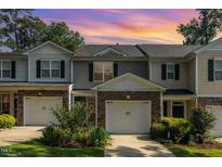 Charming townhome featuring a two-car garage, stone accents, and lovely landscaping at 4732 Altha St, Raleigh, NC 27606