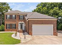 Stately brick home with manicured lawn, shutters, and attached two car garage at 5125 Pinehall Wynd, Raleigh, NC 27604