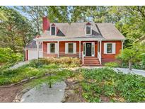Charming red home with a front porch, white trim, and a well-maintained landscaped yard at 6728 Glen Forrest Dr, Chapel Hill, NC 27517