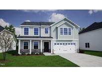 Charming two-story home with a two-car garage and well-manicured lawn at 85 Plantation Dr, Youngsville, NC 27596