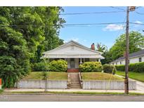 Charming home with lush greenery, and a welcoming front porch in a serene neighborhood at 907 Morehead Ave, Durham, NC 27707