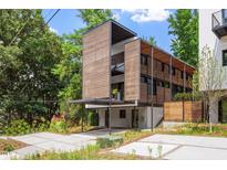 Modern home featuring wood accents, large windows, and a carport with manicured landscaping at 922 Tower St, Raleigh, NC 27607