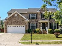Charming two-story brick home with a well-manicured lawn and a two-car garage at 1035 Evening Shade Ave, Rolesville, NC 27571
