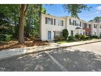 Charming townhouse with blue door, shuttered windows, and well-maintained landscaping near ample parking at 110 Virens Dr, Cary, NC 27511