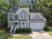Charming two-story home with attached garage, manicured landscaping, and mature trees at 116 Hidden Cellars Dr, Holly Springs, NC 27540