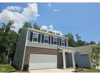 Two-story home featuring a gray exterior with brick accents and an attached two-car garage at 126 N Keatts Winner Ct, Wilson's Mills, NC 27520