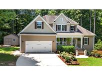 Charming two-story home with neutral-colored siding, well-manicured landscaping, and an attached two-car garage at 149 Hadley Ln, Clayton, NC 27527