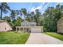 Charming two-story home with a well-maintained lawn, inviting front porch, and a two-car garage at 1909 Piperwood Ct, Durham, NC 27713