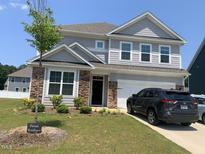 Charming two-story home with stone accents, a well-manicured lawn, and an attached two-car garage at 4108 Cross Timber Ln, Raleigh, NC 27603