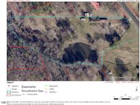 Aerial view of wooded property with pond, buildings and boundaries outlined at 4254 Bowmantown Rd, Roxboro, NC 27574