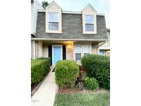 Charming townhome with a blue front door, black shutters, and manicured landscaping at 4324 Halliwell Dr, Raleigh, NC 27606